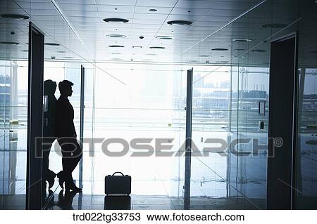Stock Image - A businessman leaning on the wall. Fotosearch