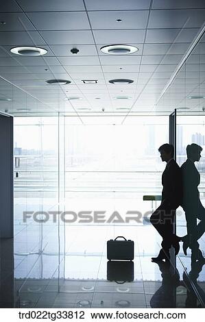 Stock Image - A businessman leaning on the wall. Fotosearch