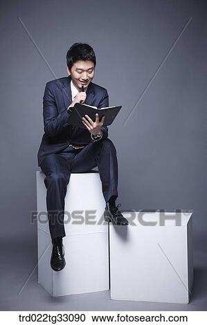 Stock Image - A businessman looking at a planner. Fotosearch