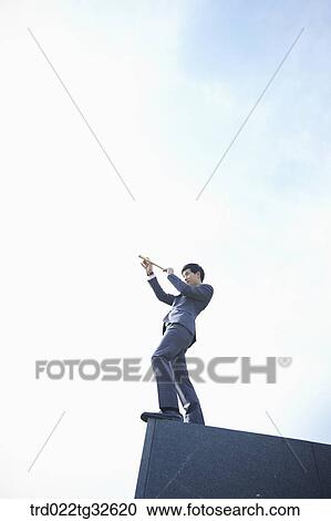 A businessman looking through the telescope View Large Photo Image Stock Image - A businessman looking through the telescope. Fotosearch
