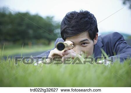A businessman looking through the telescope View Large Photo Image Stock Photo - A businessman looking through the telescope. Fotosearch