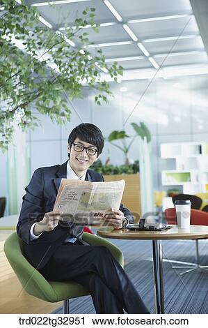 A businessman reading a newspaper in the lounge View Large Photo Image Stock Image - A businessman reading a newspaper in the lounge. Fotosearch