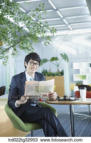 A businessman reading a newspaper in the lounge View Large Photo Image Stock Image - A businessman reading a newspaper in the lounge. Fotosearch