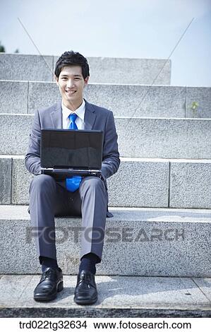 Picture - A businessman sitting with the laptop. Fotosearch