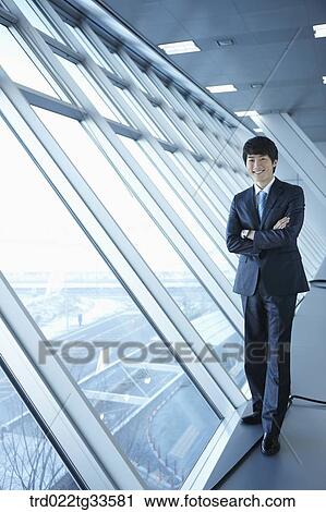 A businessman standing by the window View Large Photo Image Stock Image - A businessman standing by the window. Fotosearch