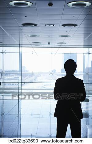 Stock Image - A businessman standing in the hallway. Fotosearch