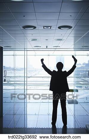 Stock Image - A businessman standing in the hallway. Fotosearch
