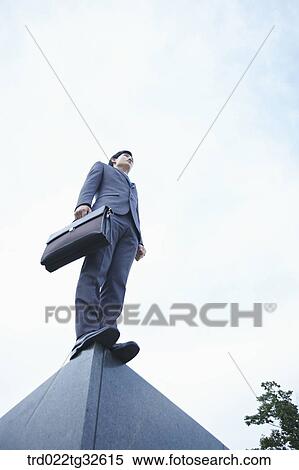 A businessman standing with the briefcase View Large Photo Image Stock Photography - A businessman standing with the briefcase. Fotosearch