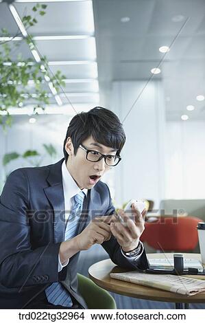 A businessman surprised at the mobile phone View Large Photo Image Picture - A businessman surprised at the mobile phone. Fotosearch