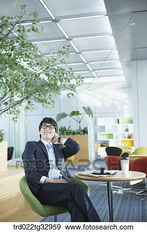 Stock Photo - A businessman taking a break in the lounge. Fotosearch