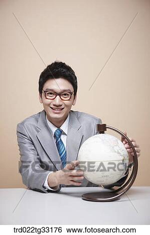 Stock Photograph - A businessman with a globe. Fotosearch