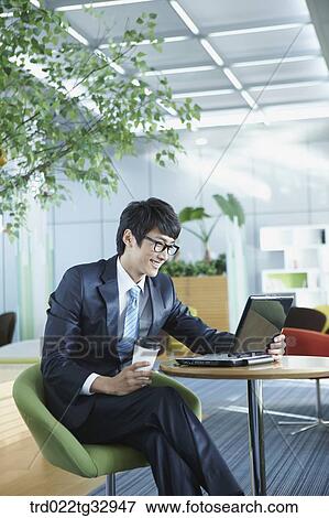 Stock Photo - A businessman working in the lounge. Fotosearch