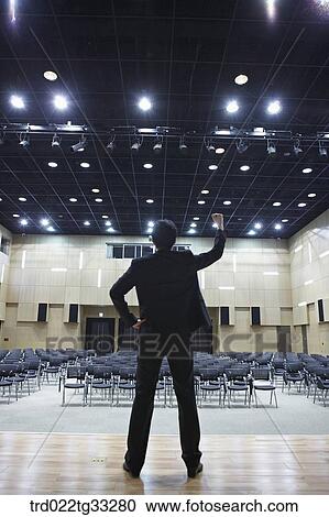 Stock Image - A cheerful businessman on the stage. Fotosearch