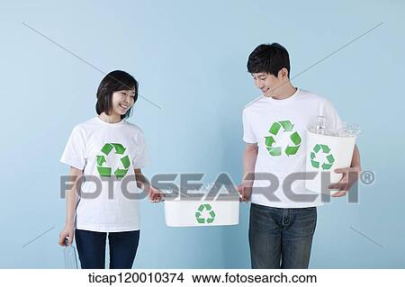 A couple smiling with recycling bin View Large Photo Image Picture - A couple smiling with recycling bin . Fotosearch