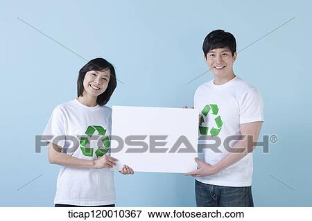 Stock Photo - A couple wearing recycling shirt with white board . Fotosearch