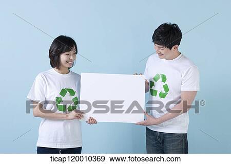 A couple wearing recycling shirt with white board View Large Photo Image Stock Photo - A couple wearing recycling shirt with white board . Fotosearch