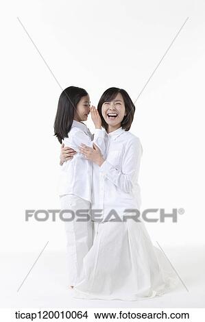A daughter whispering to smiling mother View Large Photo Image Picture - A daughter whispering to smiling mother. Fotosearch