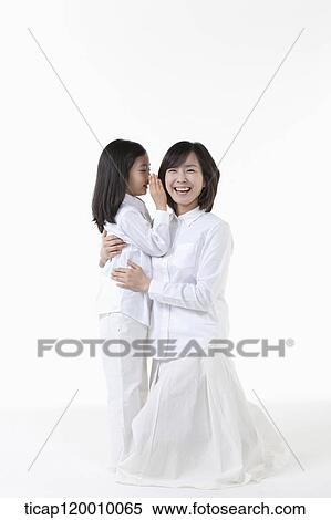 Stock Photography - A daughter whispering to smiling mother. Fotosearch