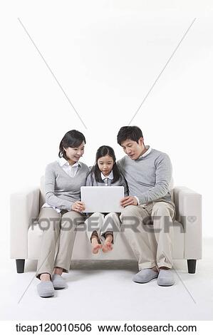 Stock Photograph - A family looking at the laptop. Fotosearch