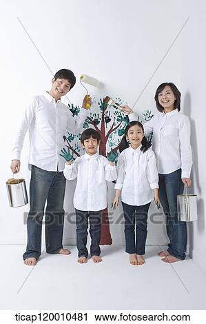 Stock Image - A family painting the tree on the wall. Fotosearch
