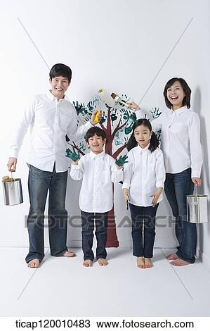 Stock Image - A family painting the tree on the wall. Fotosearch