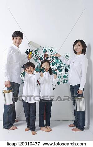 Stock Photo - A family painting the tree on the wall. Fotosearch