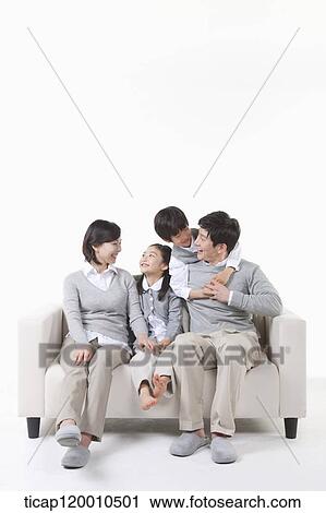 A family sitting on the couch View Large Photo Image Stock Image - A family sitting on the couch. Fotosearch