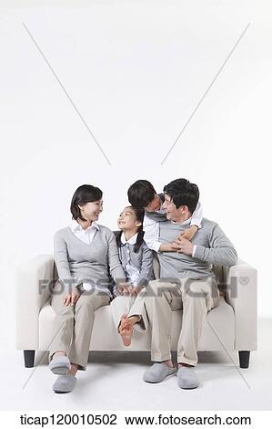 A family sitting on the couch View Large Photo Image Stock Image - A family sitting on the couch. Fotosearch