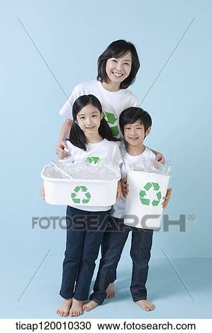 Stock Image - A family smiling with recycling bin . Fotosearch