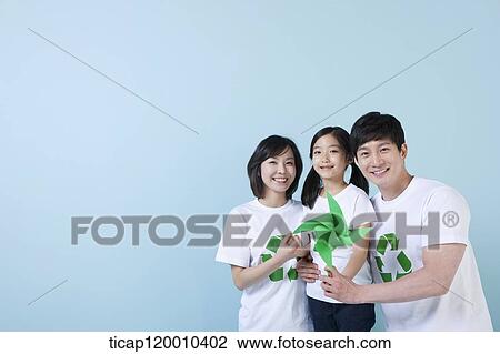 Stock Image - A family wearing recycling shirt with green pinwheel. Fotosearch