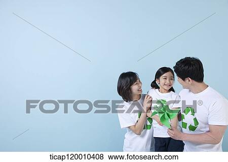 Stock Photo - A family wearing recycling shirt with green pinwheel. Fotosearch
