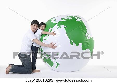 Stock Image - A father and daughter hugging a green globe. Fotosearch