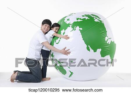 Stock Photography - A father and daughter hugging a green globe. Fotosearch
