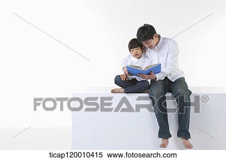 Stock Photography - A father and son reading a book. Fotosearch