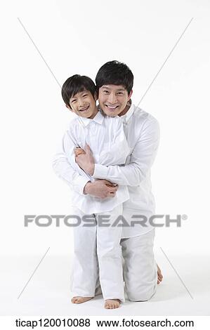 Stock Photo - A father hugging his son from the back. Fotosearch