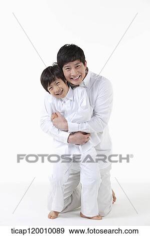 Stock Photo - A father hugging his son from the back. Fotosearch