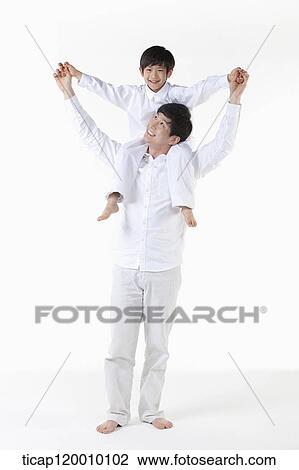 Stock Image - A father putting his son on his shoulders. Fotosearch