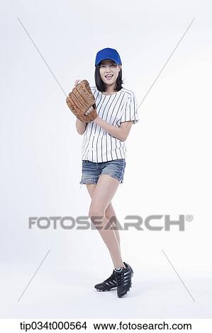 Picture - A female baseball player pitching a ball. Fotosearch