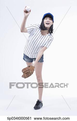 Stock Image - A female baseball player pitching a ball. Fotosearch