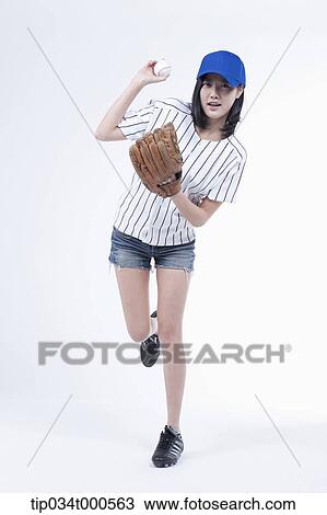 Stock Image - A female baseball player pitching a ball. Fotosearch