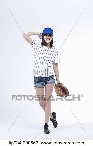 Stock Photo - A female baseball player pitching a ball. Fotosearch