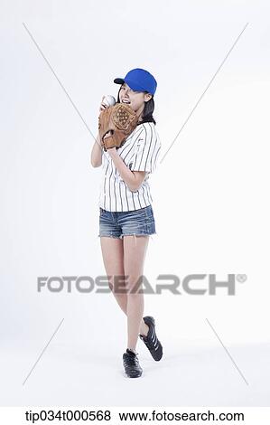 Stock Photo - A female baseball player pitching a ball. Fotosearch