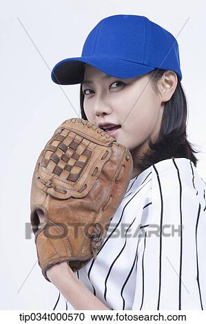 Stock Image - A female baseball player wearing a glove. Fotosearch
