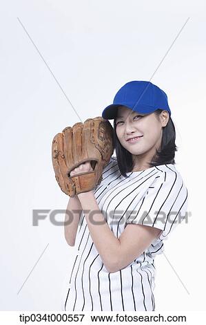 Stock Photo - A female baseball player wearing a glove. Fotosearch
