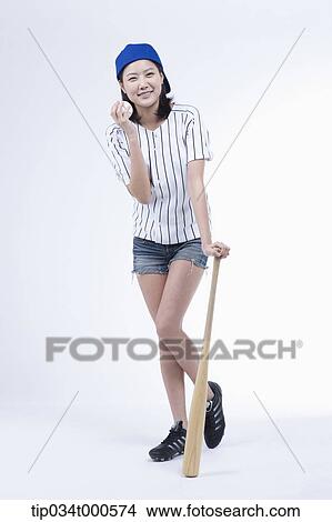 Picture - A female baseball player with a ball and bat. Fotosearch