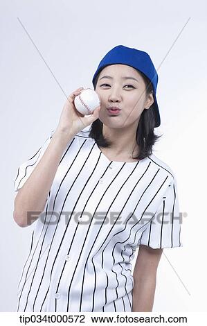 Stock Image - A female baseball player with a ball. Fotosearch