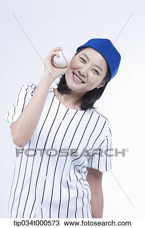 Stock Image - A female baseball player with a ball. Fotosearch