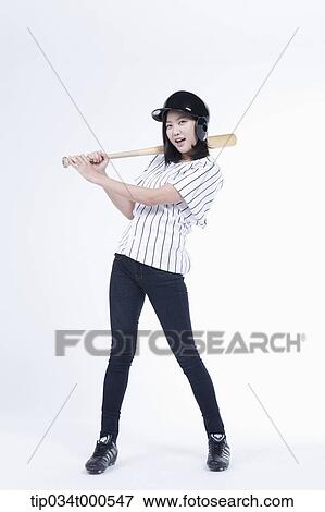 Stock Photo - A female baseball player with a bat. Fotosearch