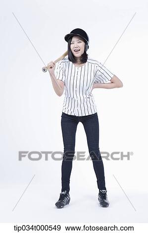 Stock Photo - A female baseball player with a bat. Fotosearch