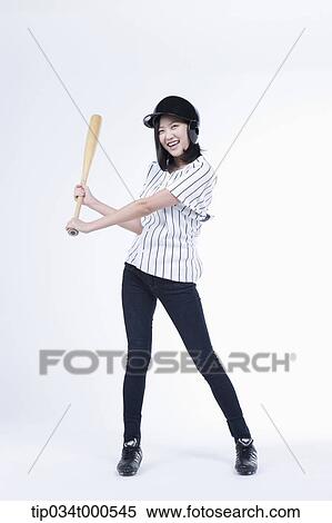 Stock Photography - A female baseball player with a bat. Fotosearch